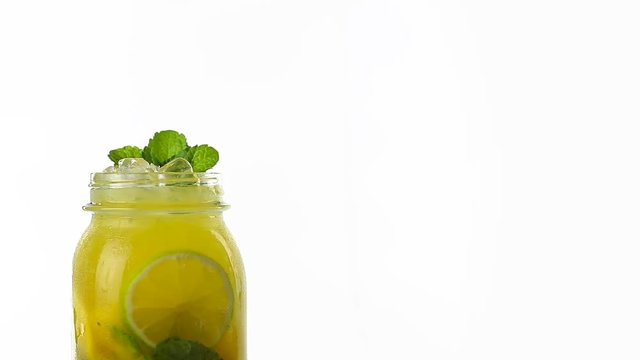Hand made citrus lemonade rotates on a white background