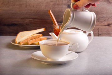 Pouring milk into white cup