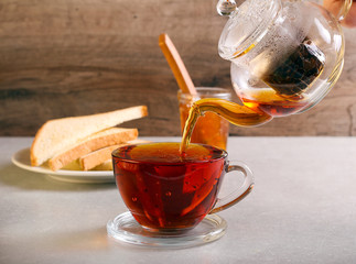 Pouring black tea in to transparent glass