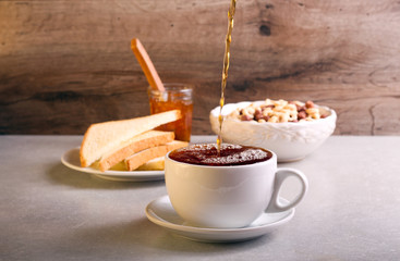 Pouring black tea into cup