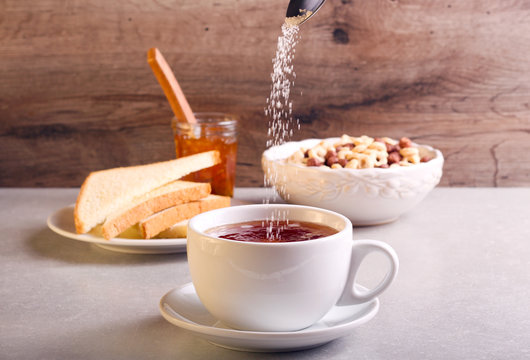 Adding Sugar Into Tea In A Cup