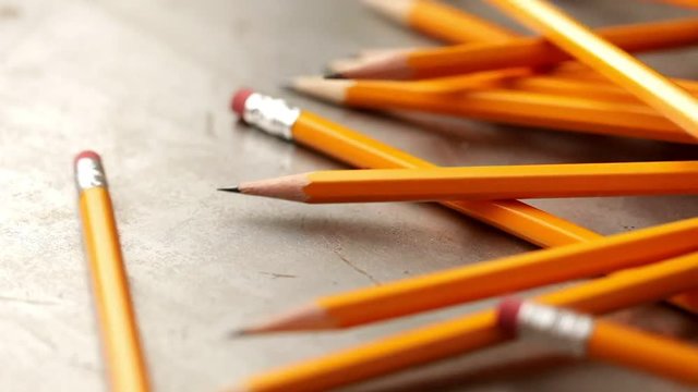 Typical yellow pencils rolling down a metal ramp.