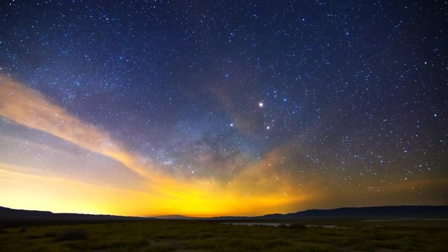 Astrophotography time lapse with tilt down motion of Milky Way galaxy rising over Desert Gold wildflower super bloom 2016 in Carrizo Plain National Monument, California