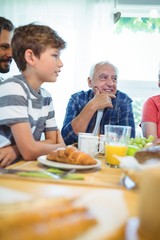 Multi-generation family sitting at breakfast table