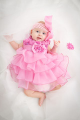 Fototapeta premium Portrait of a beautiful little baby girl in pink