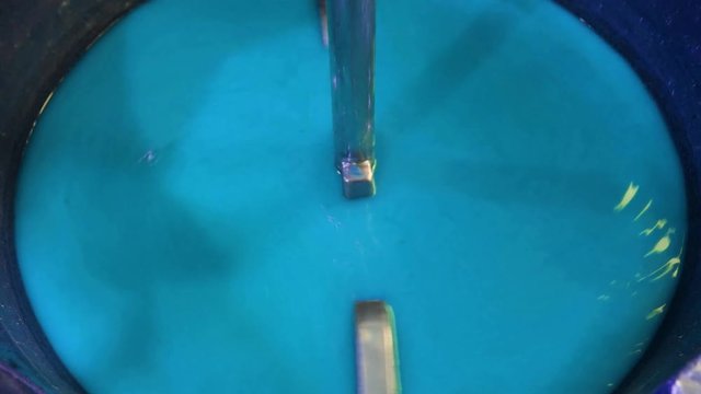 Blue paint being mixed in factory