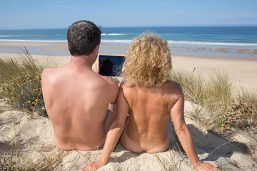 Outdoor kussens Relaxing nudist couple sitting on holidays at the sea © OceanProd