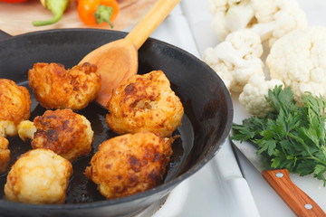 Frying breaded cauliflowers in the pan on the stove