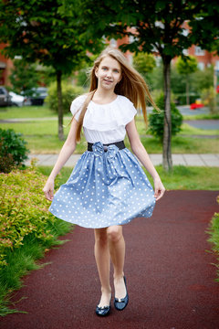 Portrait of a beautiful young girl in the Park skirt blouse nature fashion style