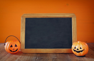 Cute pumpkins next to blank blackboard