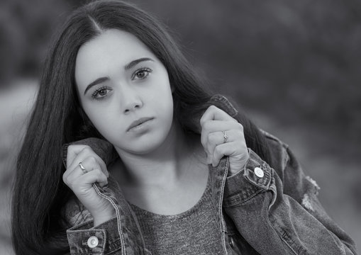 Portrait of young woman clutching the lapels of his jacket.