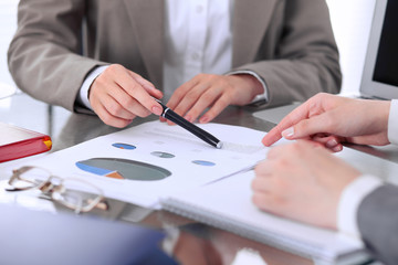 Group of business people at meeting  discussing financial results. Women pointing into laptop computer monitor