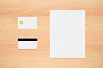 Mock-up of credit card with two sides and paper sheet on office desk