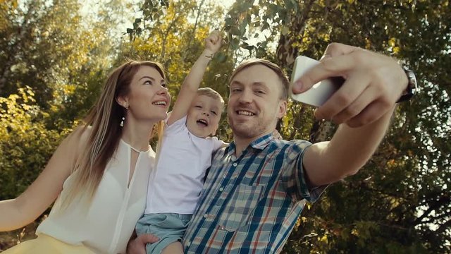 Happy family taking pictures of themselves against forest background