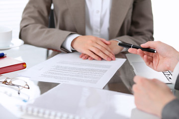 Group of business people and lawyers discussing contract sitting at the table. Woman chief is taking pen for signing papers