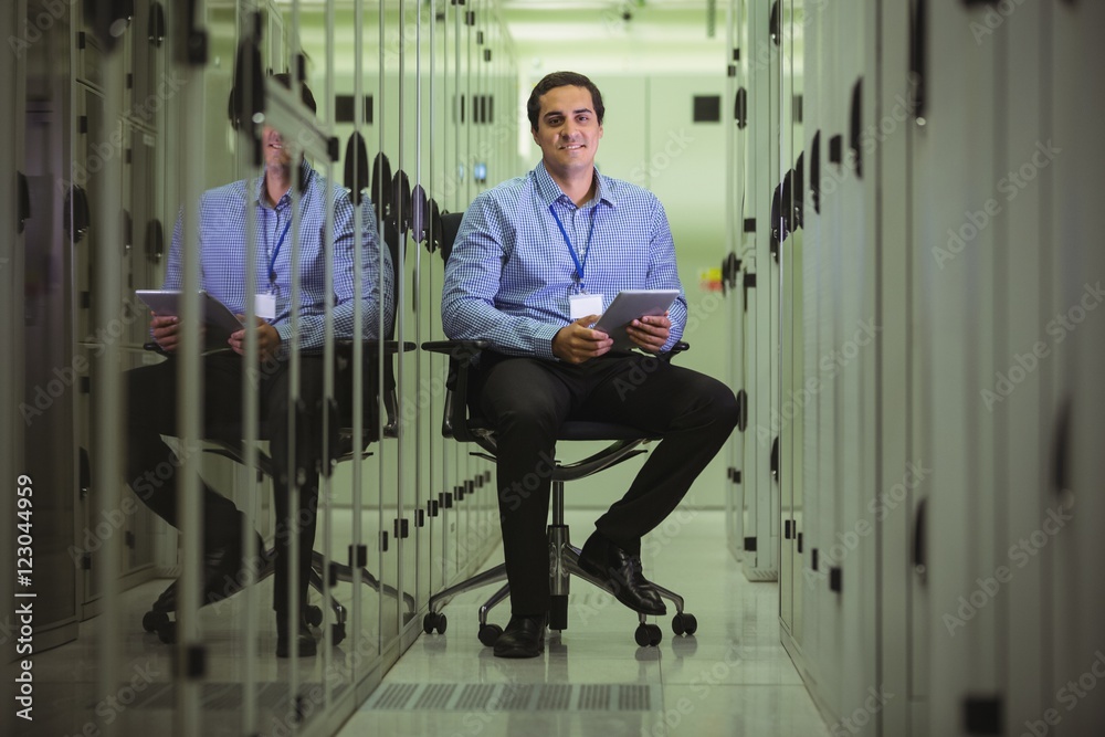 Poster portrait of technician siting on chair and using digital tablet
