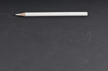 white pencil in the shell on blackboard with copy space