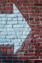 Arrow sign on red brick wall