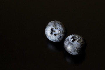 Blueberries on black background. Reflection