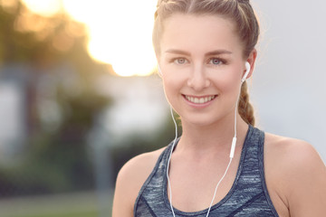 Hübsche junge Frau hört Musik mit Ohrhörern