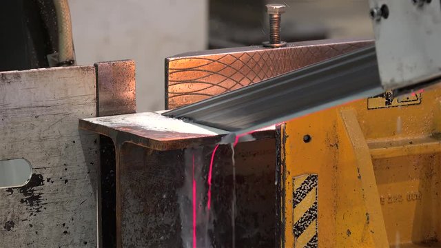 Automatic Band Saw Machine is sawing a metal I-beam.