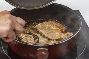 Mamá preparando en casa unas chuletas con salsa de cebolla caramelizada.