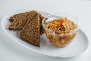 rye bread and a dish of vegetable stew on a white plate