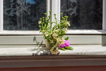 An old house window decorated with flower pots