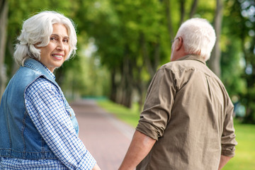 Joyful married couple enjoying walk in park