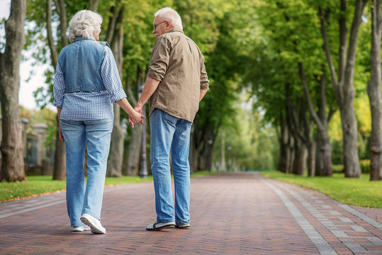 Happy mature man and woman having walk together