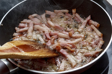 Mamá friendo beicon en casa.