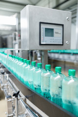 Robotic factory line for processing and bottling of pure spring water into canisters and bottles. Selective focus. Short depth of field.