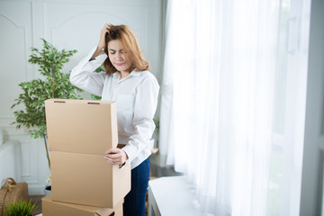 home, post, delivery concept - young woman opening cardboard box at home.