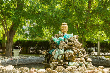 Fountain of the stones with a jug in summer Park