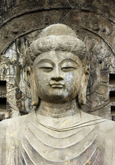   Stone old statue of a Buddha in Chinese . Face close up