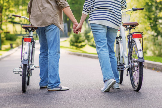 Mature loving couple walking with bikes