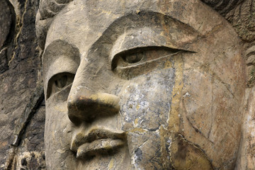 Fototapeta na wymiar Face close up Buddha ,Stone old statue of a Buddha in Chinese
