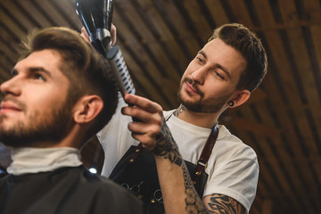 fashionable barber doing haircut indoors