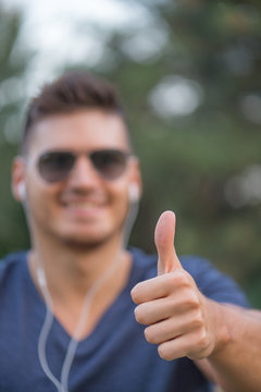 Happy, young, good looking guy with thumbs up