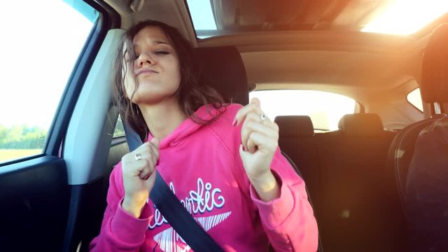 Teen beautiful girl sings and dances in the car on the sunshine background. 3840x2160