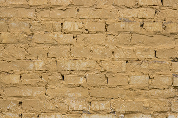 Old worn yellow brick wall background.