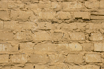 Old worn yellow brick wall background.