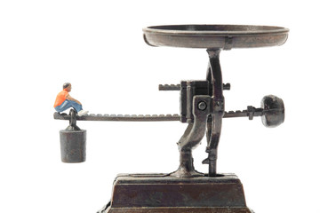 Toy people / View of miniature toy people sit on scales.