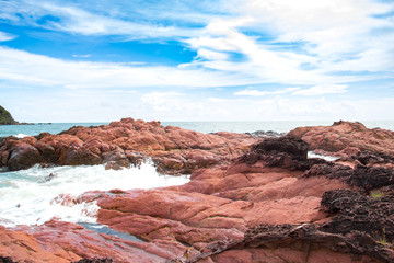 Obraz premium Pink stone (Arkose) near the beach , Waves hit the pink stone ,