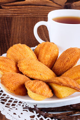 Homemade vanilla cookies Madeleine with a cup of tea on a wooden