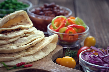 Mexican corn tortilla tacos with vegetables on wooden background 