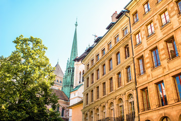 Obraz premium Street view with old buildings and Saint Pierre church's spire in the old town of Geneva city in Switzerland