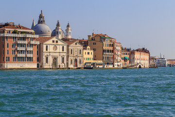 Fototapeta na wymiar Facades of houses and the bridge, the view from the water in the channel of Giudecca in the Italian city of Venice