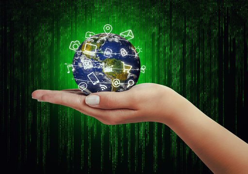 hand holding globe and media icons flying in front matrix background