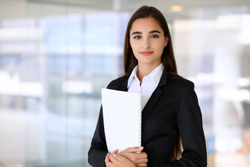 Young brunette businesswoman or student girl looking at camera